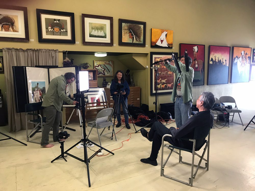 A small white dog in a stroller outside a clothing store.