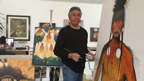 Man creating indigenous-themed art in studio