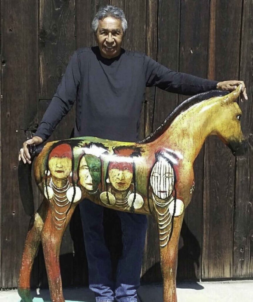 A small white dog in a stroller outside a clothing store.