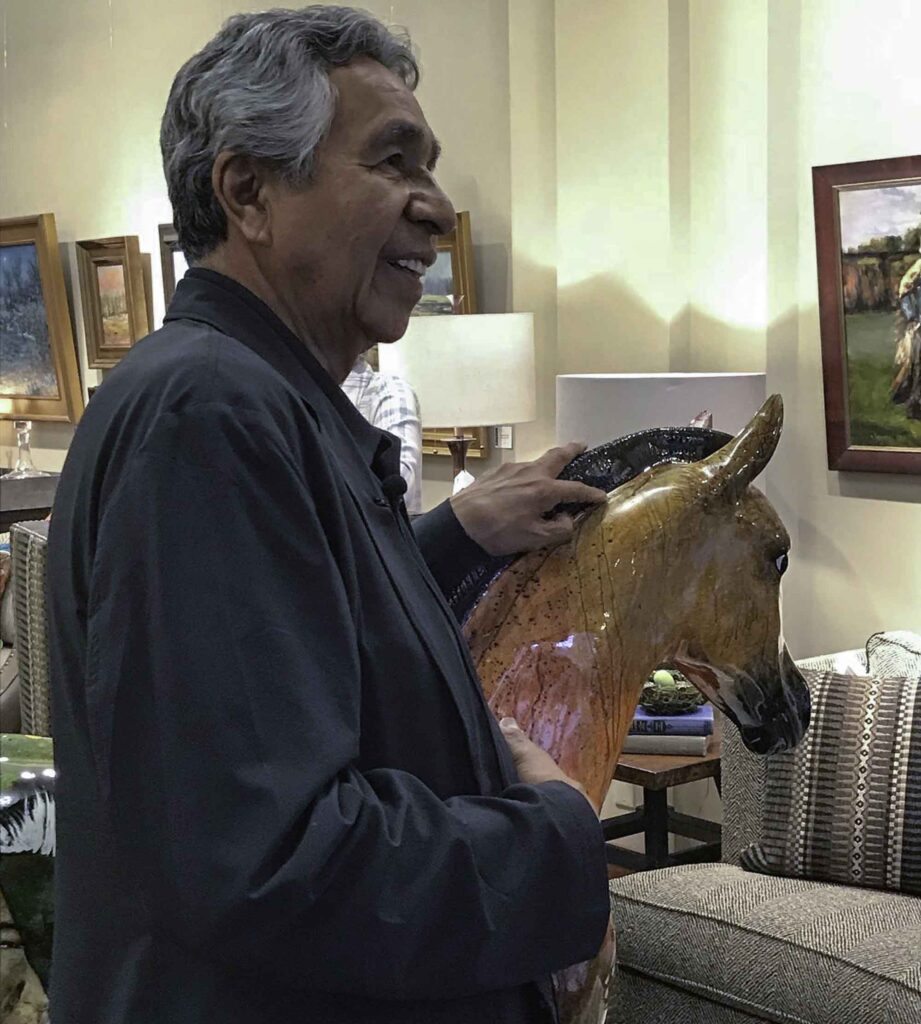 A small white dog in a stroller outside a clothing store.