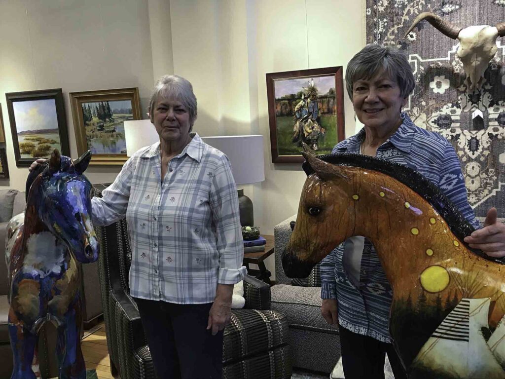 A small white dog in a stroller outside a clothing store.