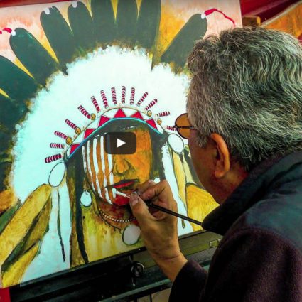 Man working on colorful tribal artwork