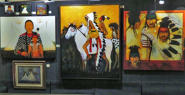 A small white dog in a stroller outside a clothing store.