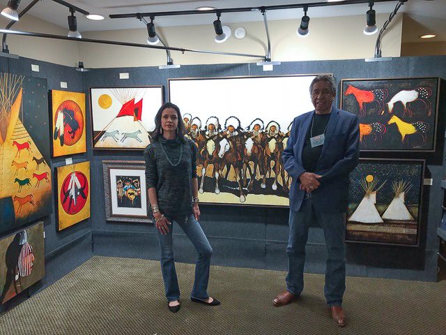 A small white dog in a stroller outside a clothing store.