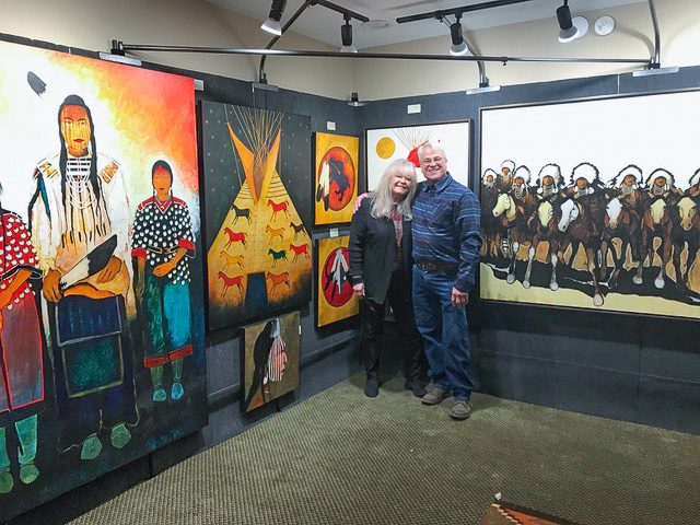 A small white dog in a stroller outside a clothing store.
