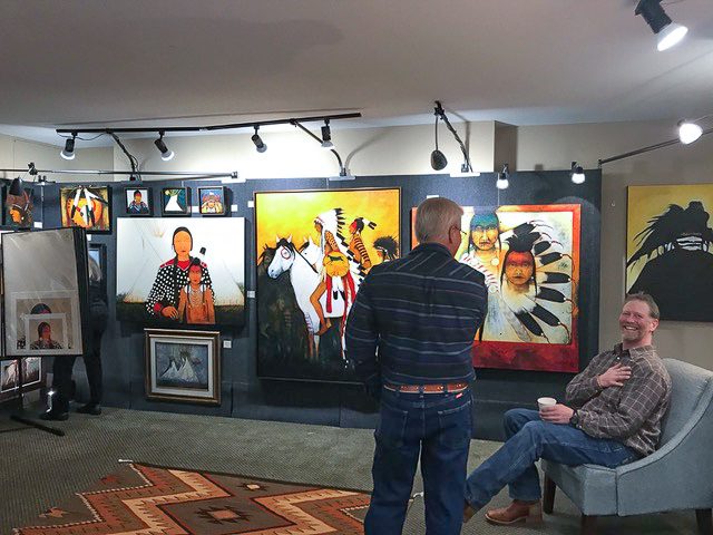 A small white dog in a stroller outside a clothing store.