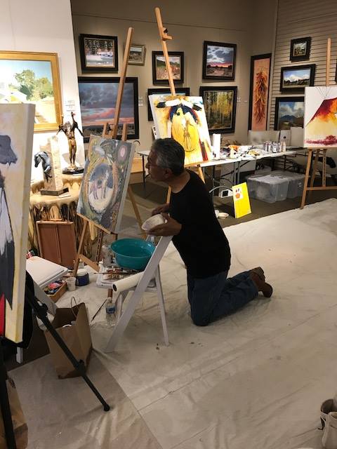 A small white dog in a stroller outside a clothing store.