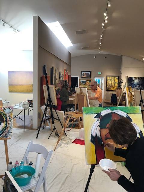 A small white dog in a stroller outside a clothing store.