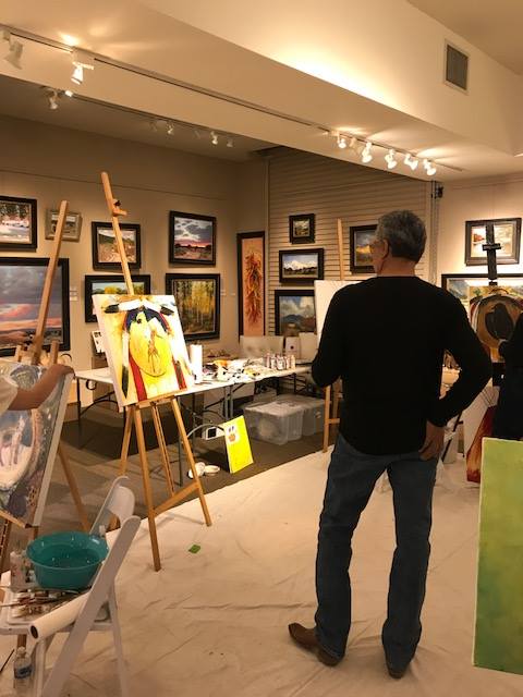 A small white dog in a stroller outside a clothing store.