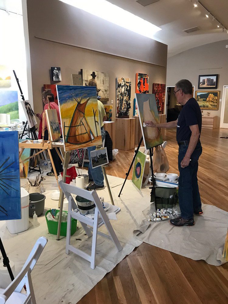 A small white dog in a stroller outside a clothing store.