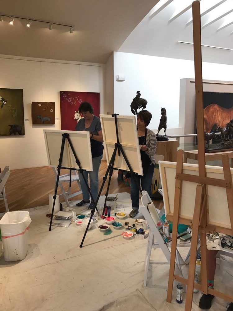 A small white dog in a stroller outside a clothing store.