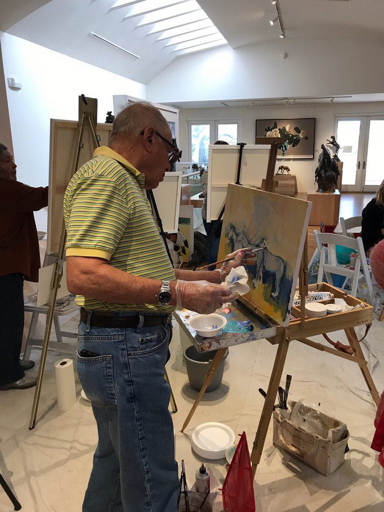 A small white dog in a stroller outside a clothing store.