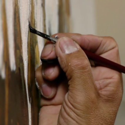 Artist's hand detailing a painting
