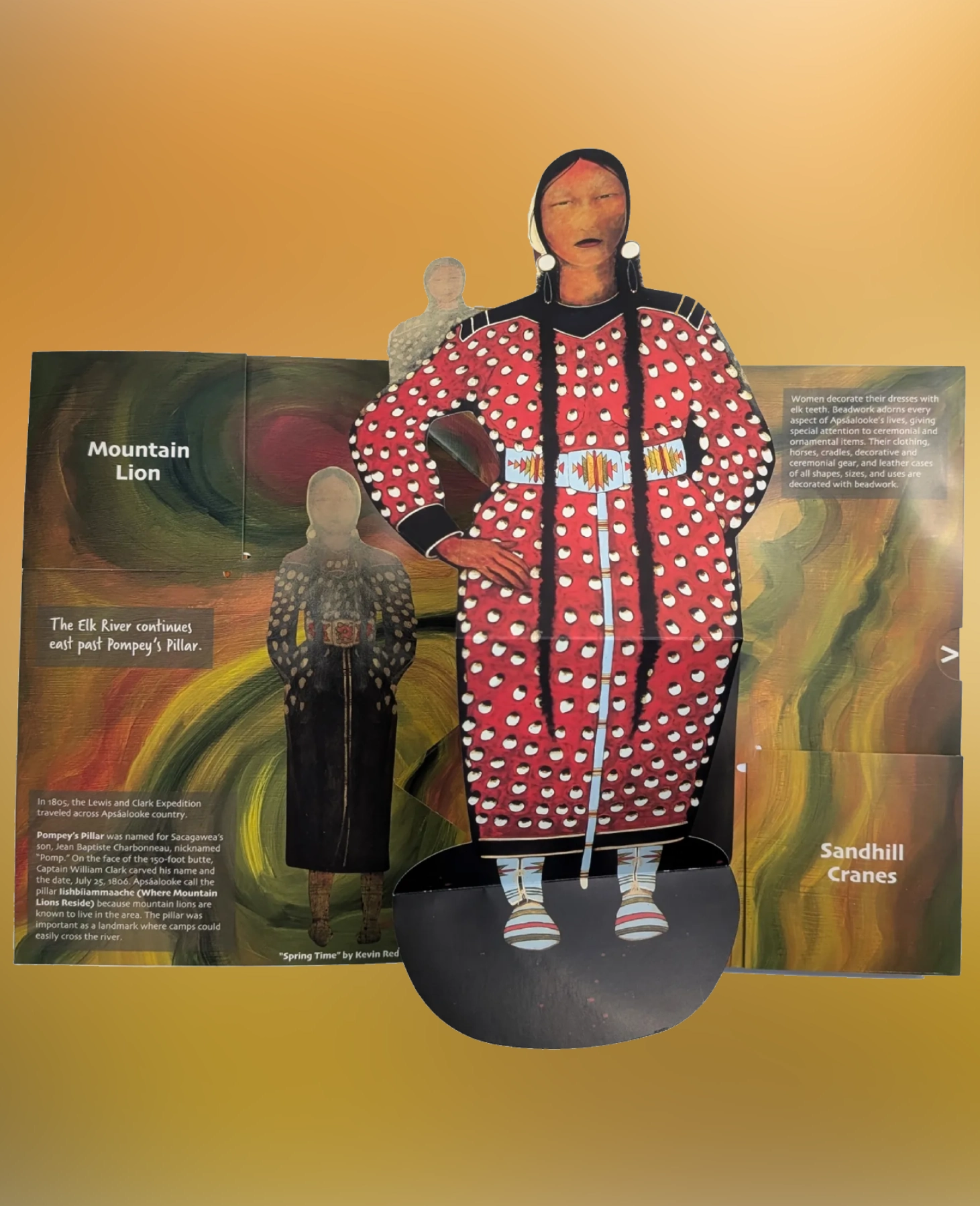 A mannequin dressed in a vibrant, patterned outfit with a matching headwrap.