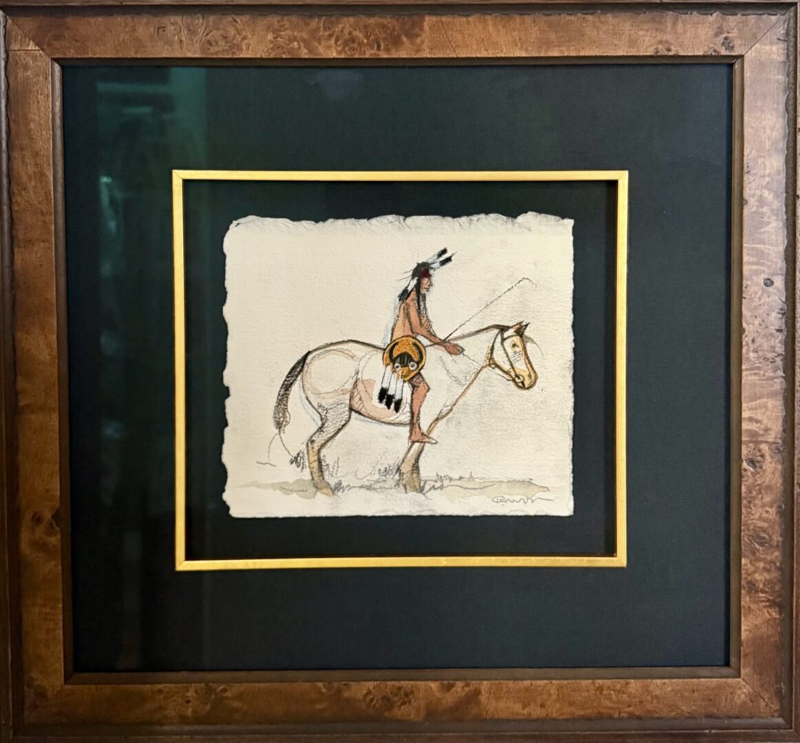 Framed artwork of a Native American on horseback with a shield.