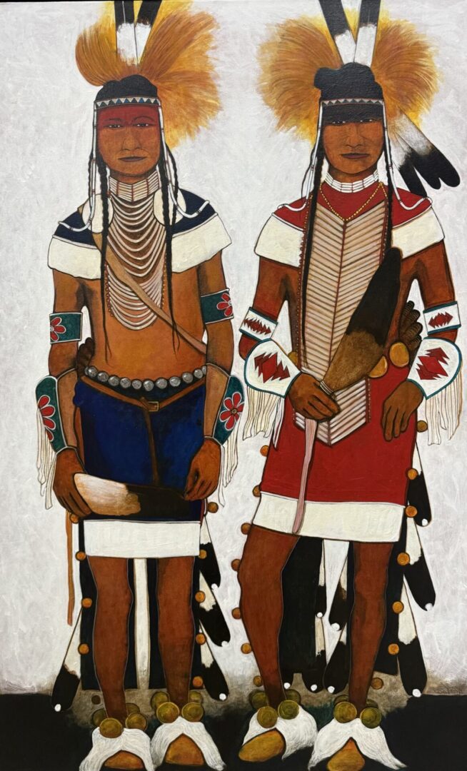 Two Native American men in traditional regalia with feathered headdresses and decorated attire.