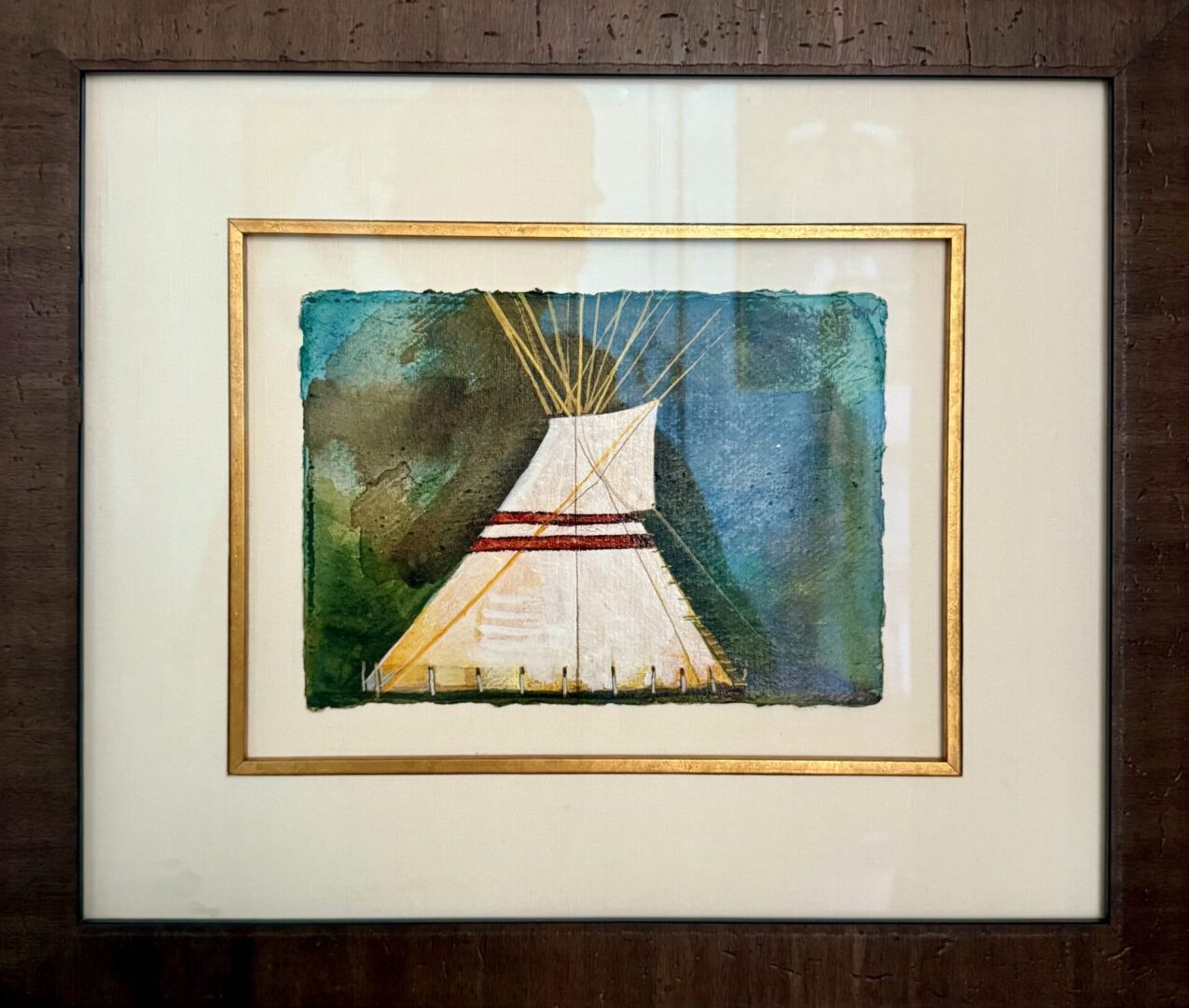 Framed painting of a Native American tipi against a blue and green background.