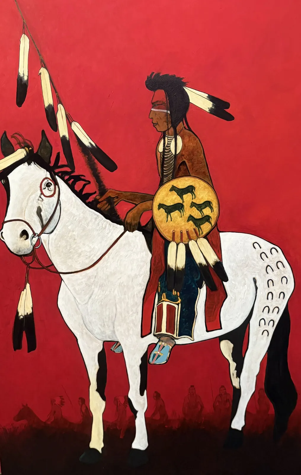 Native American warrior on a white horse against a red background.