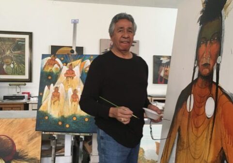 Man creating indigenous-themed art in studio